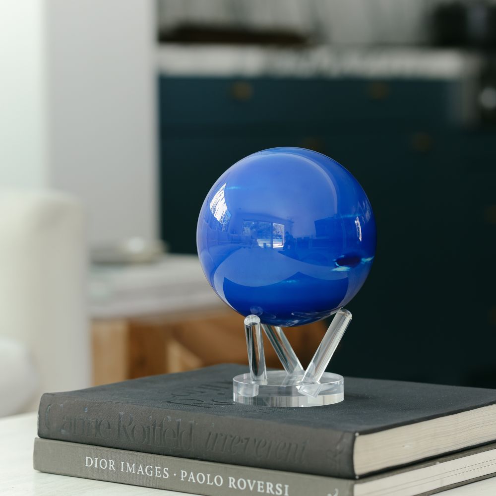 Neptune MOVA Globe displayed on stacked books with acrylic base