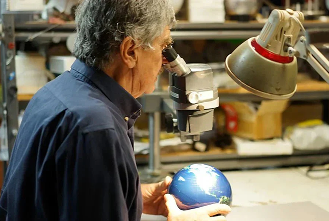 MOVA craftsman inspecting a globe with precision and innovation