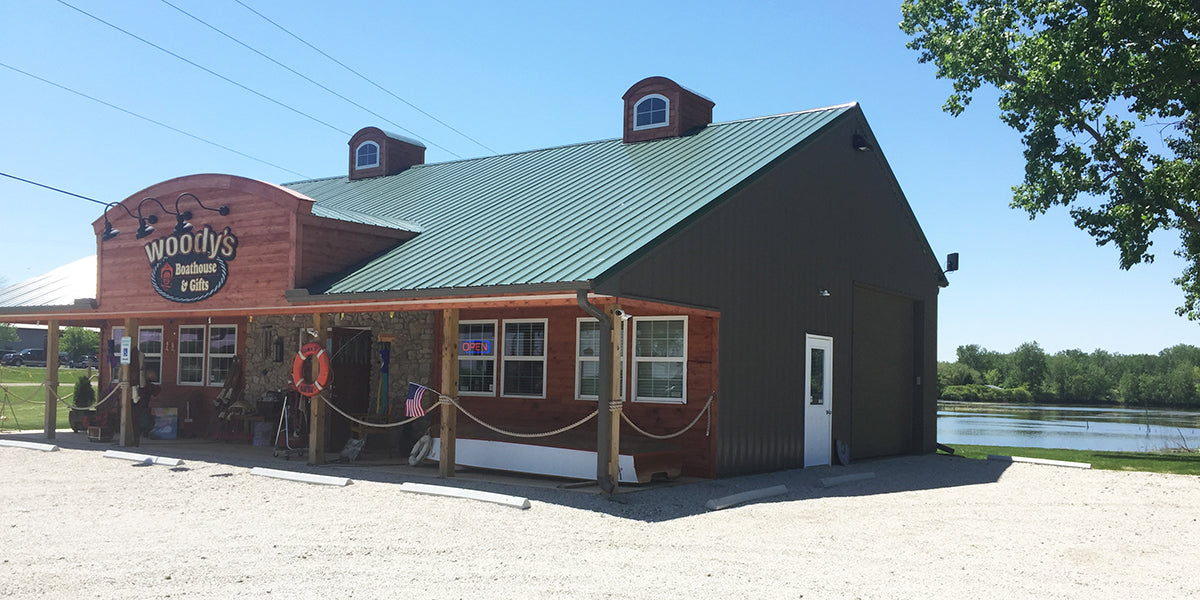 Reseller Spotlight featuring Woody’s Boathouse and Gifts riverside storefront with rustic outdoor architecture