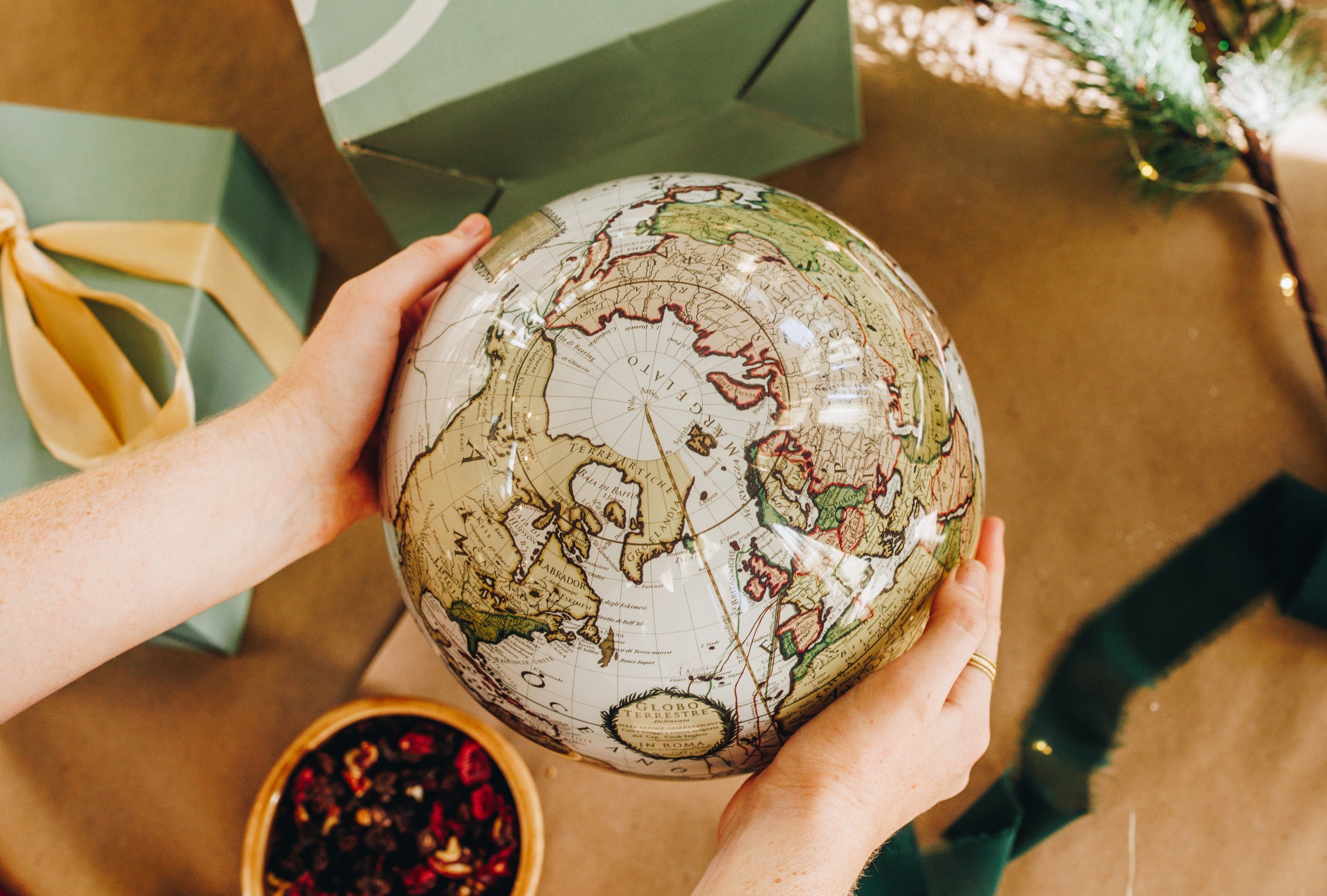 Antique-style MOVA globe held as a luxury holiday gift idea
