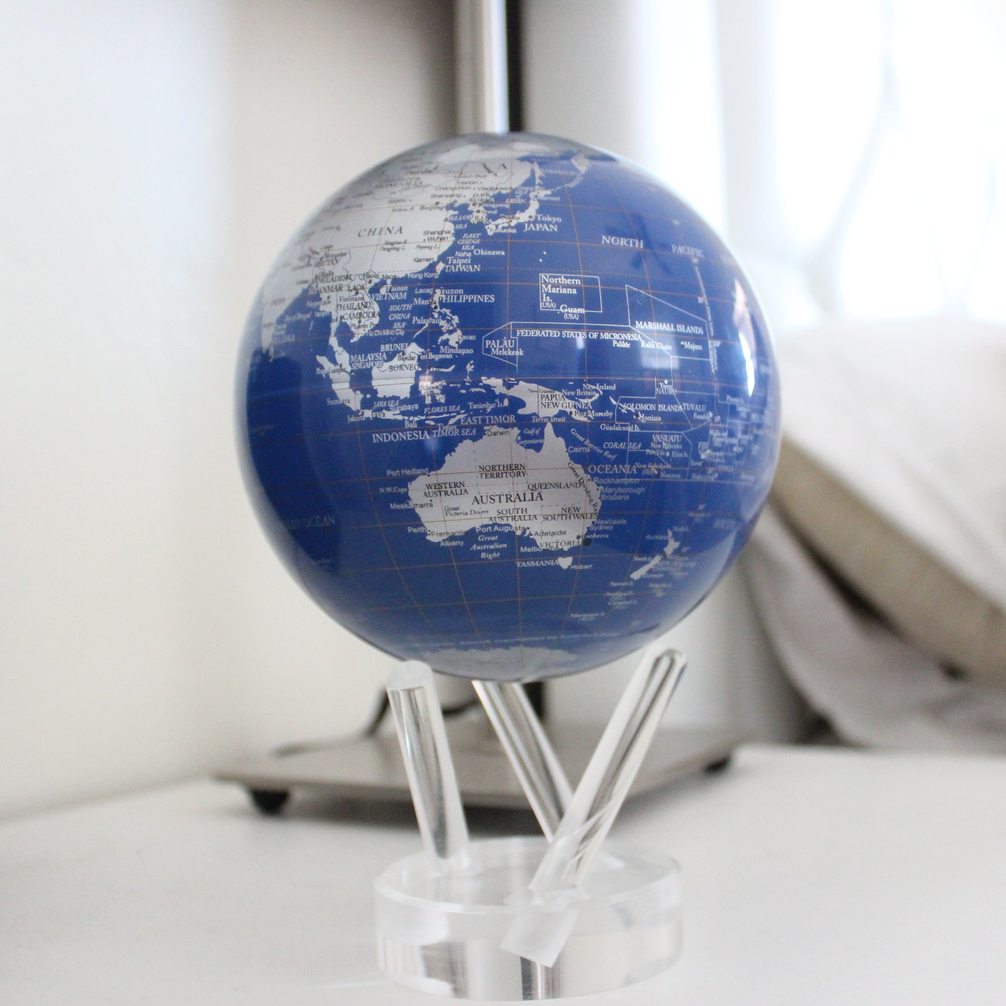 Royal Blue &amp; Silver MOVA Globe displayed on a bedside table in a modern bedroom setting