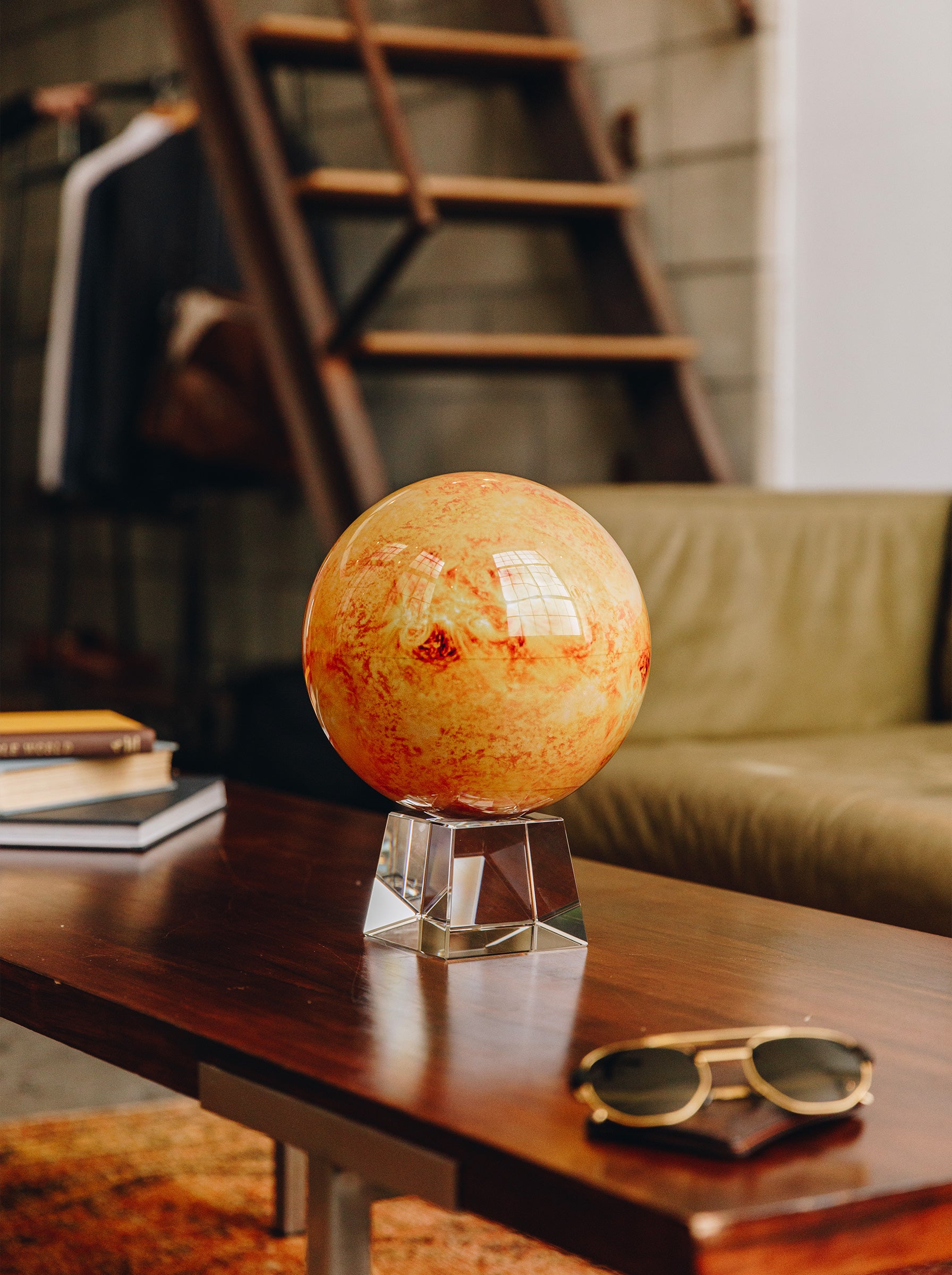 Sun MOVA globe displayed on a coffee table in a modern industrial living room with warm luxury decor