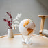 White and gold metallic MOVA globe with acrylic base on a light wood table in a Scandinavian interior
