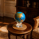 Cerulean Blue & Gold MOVA Globe displayed atop a classic wooden side table in an elegant library interior.