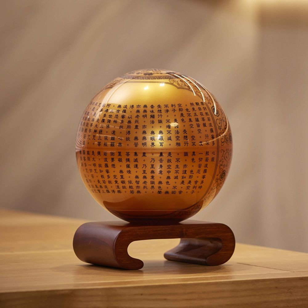 Heart Sutra MOVA Globe displayed on a wooden table with a warm, serene ambiance
