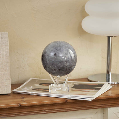 Moon MOVA Globe on console table beside magazines and lamp