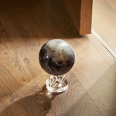 Moon MOVA Globe displayed on hardwood floor with acrylic base