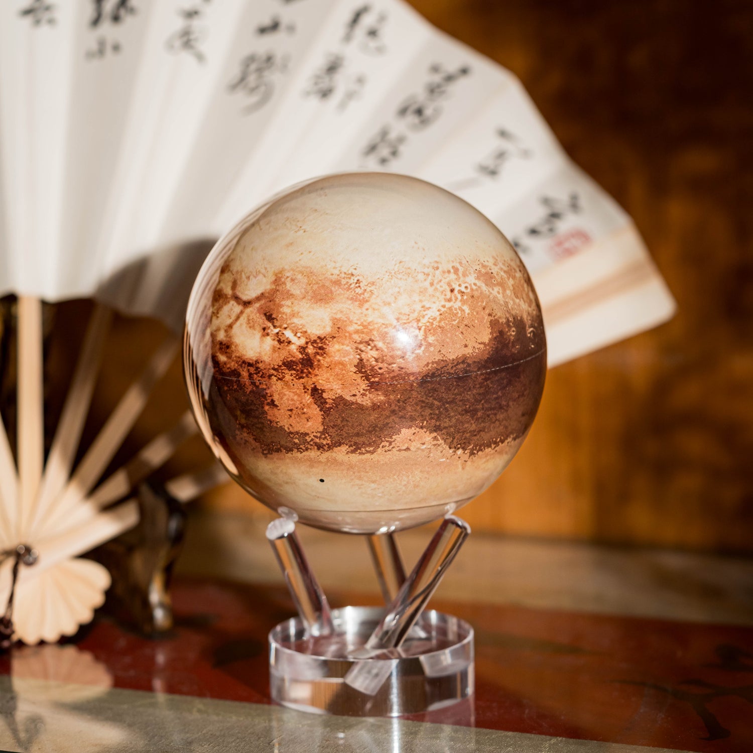 Pluto MOVA Globe with acrylic base and detailed Pluto surface artwork in a study setting