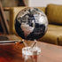 Silver and black metallic MOVA globe with acrylic base displayed on a wooden desk in a modern office interior