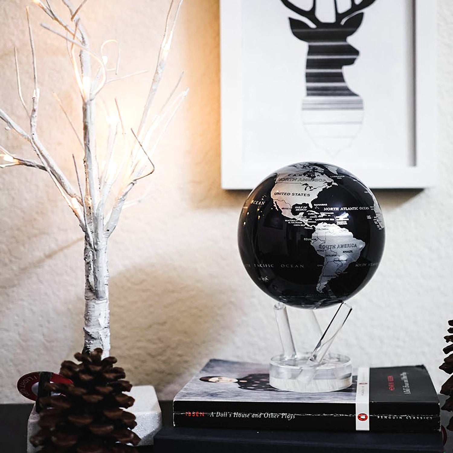 Jet Black &amp; Silver MOVA Globe displayed on book with decorative accents