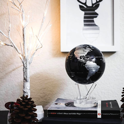 Jet Black &amp; Silver MOVA Globe displayed on book with decorative accents