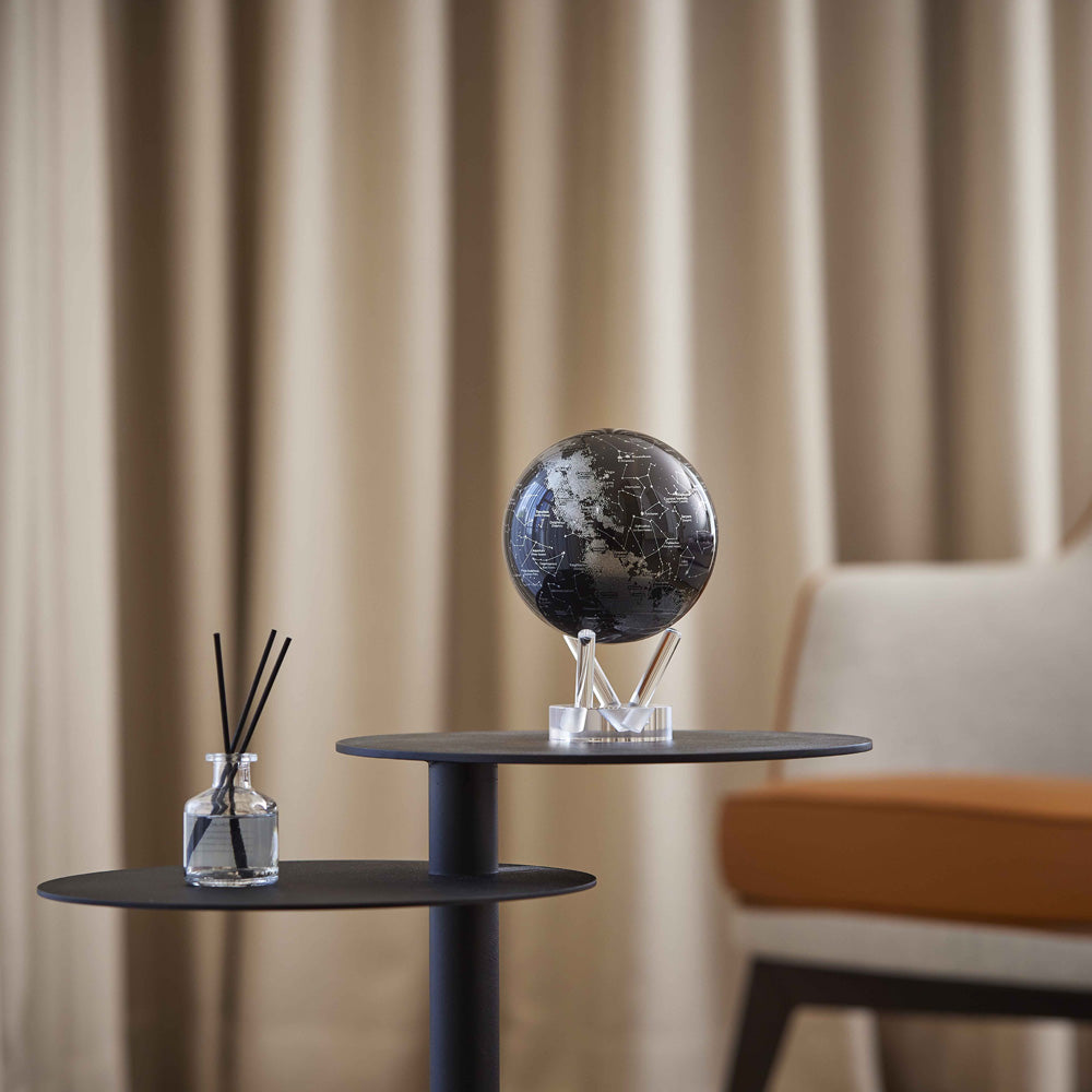 Constellations MOVA Globe on a modern side table, showcasing celestial star map artwork