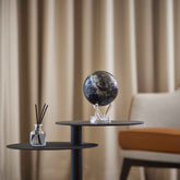 Constellations MOVA Globe on a modern side table, showcasing celestial star map artwork