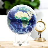 Earth with Clouds MOVA Globe on acrylic stand beside vintage clock, perfect for study or office art piece