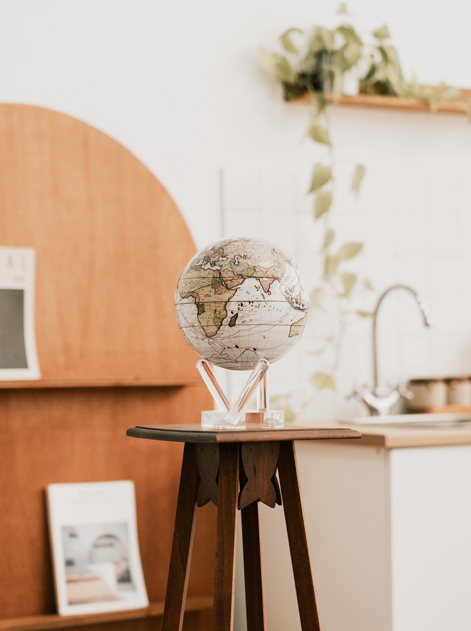 Antique cassini white map MOVA globe displayed on acrylic base in a warm modern minimalist home interior setting