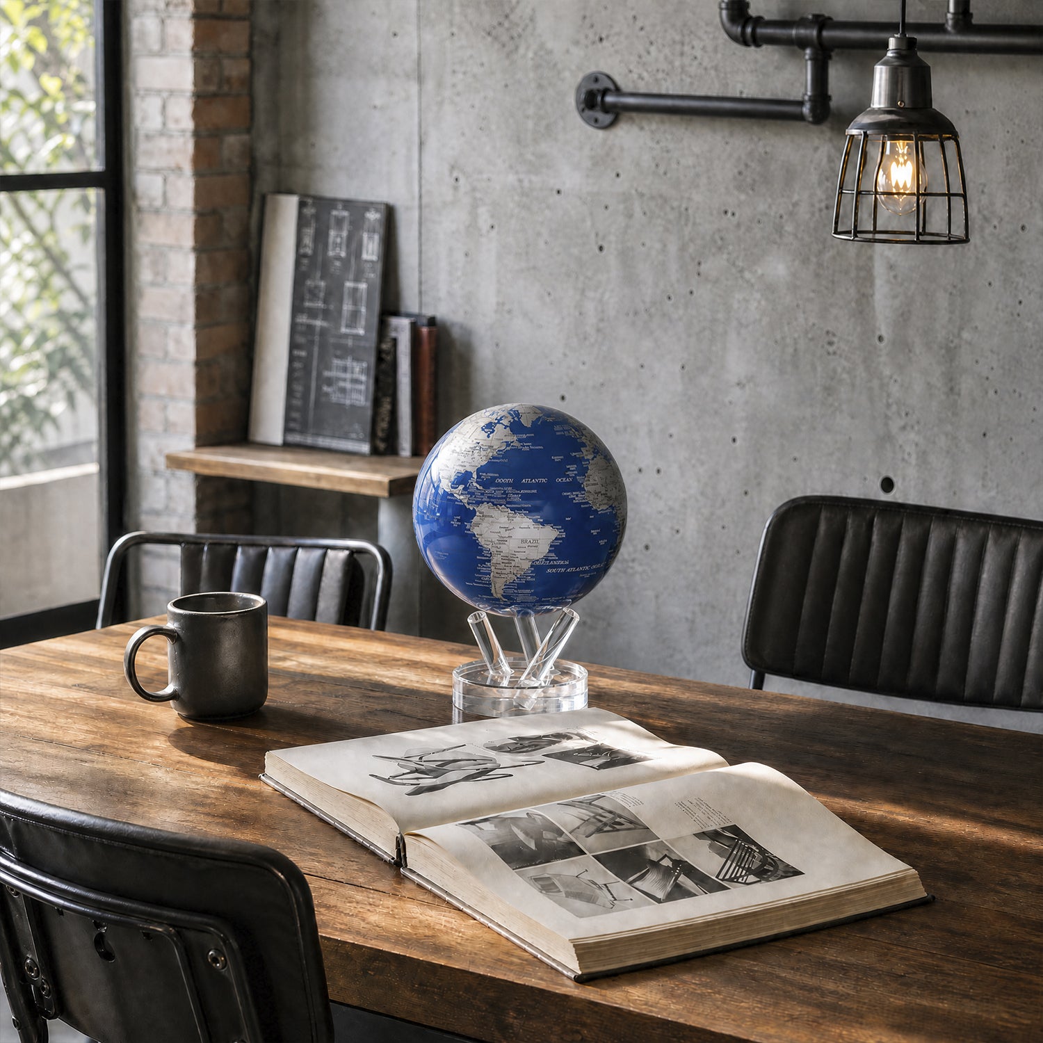 Royal Blue &amp; Silver MOVA Globe on a wooden desk beside an open book in a contemporary office