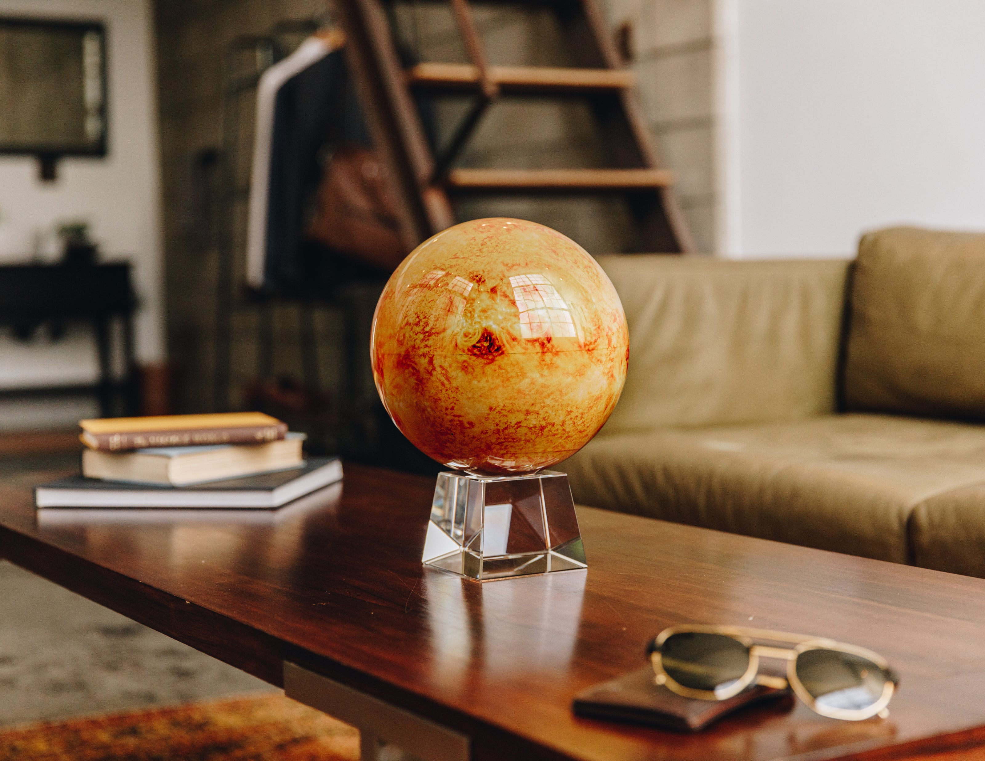 Venus MOVA globe displayed on a coffee table in a cozy modern living room