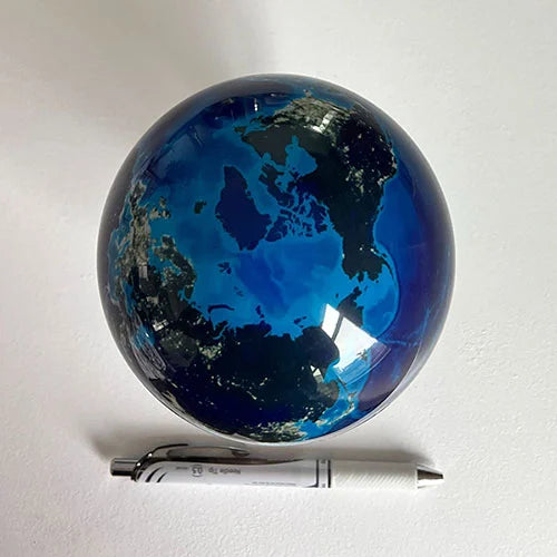 MOVA globe displayed beside pen for size comparison