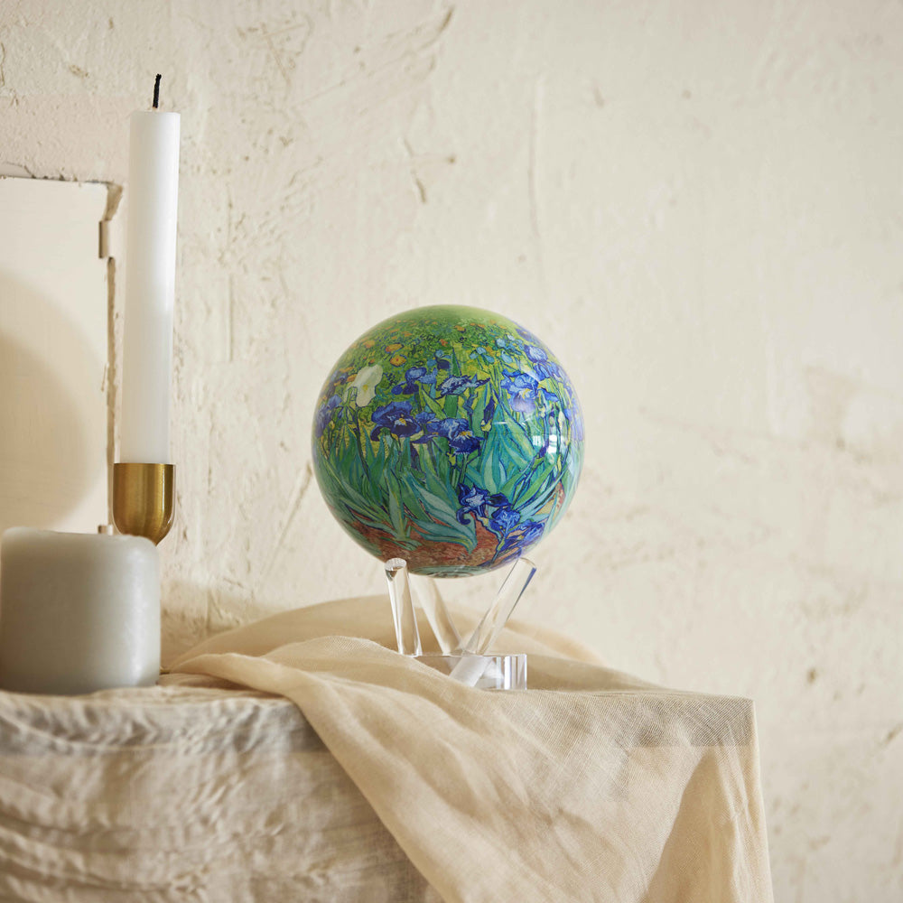 Van Gogh Irises MOVA Globe displayed on a draped console table with artistic home decor accents
