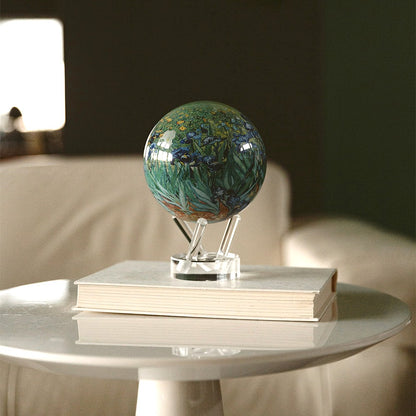 Van Gogh Irises MOVA Globe on stacked books, showcasing iconic floral artwork in a cozy room