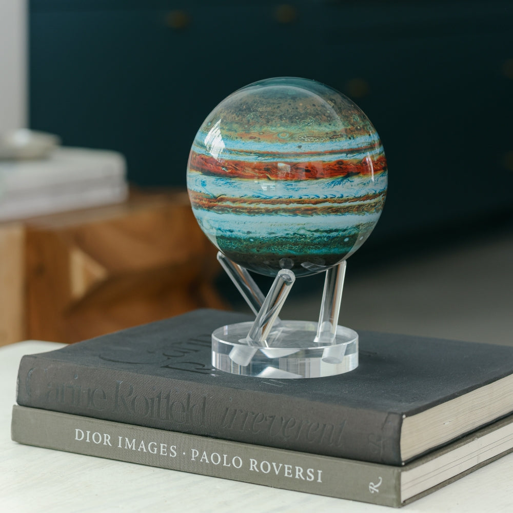 Jupiter MOVA Globe displayed on stacked books with acrylic base