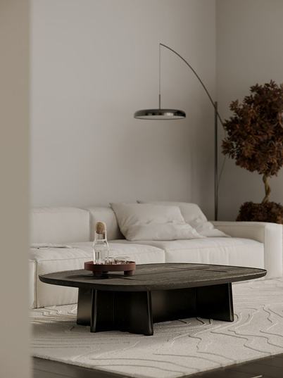 Minimalist modern living room with curved black floor lamp, white sofa, and contemporary neutral interior decor