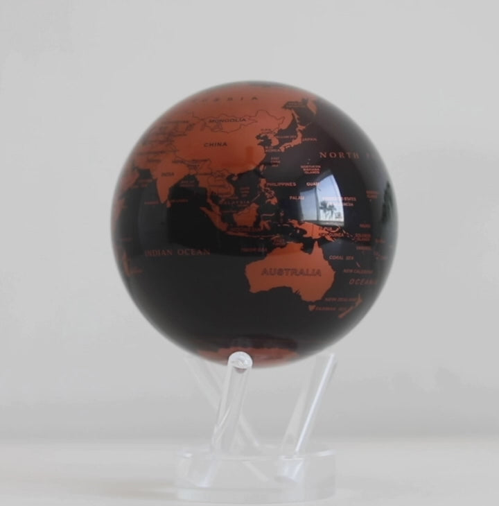 Copper MOVA globe rotating smoothly on acrylic base in luxury product video