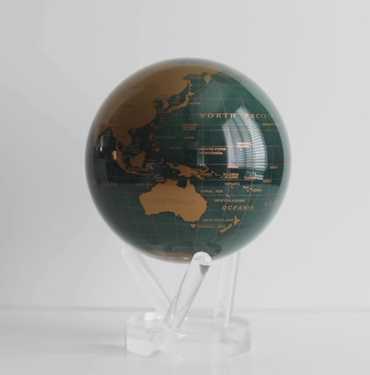 Emerland green and gold MOVA globe rotating smoothly on acrylic base in product showcase video