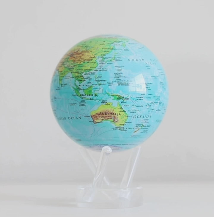 ocean blue relief MOVA globe rotating smoothly on acrylic base in celestial themed display video
