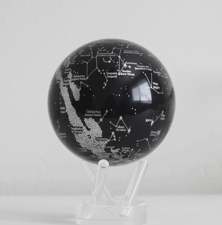 Black constellation MOVA globe rotating on acrylic base in celestial product showcase video