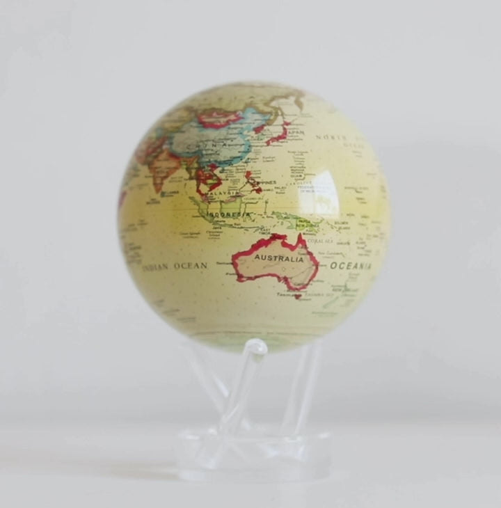 Antique yellow political MOVA globe rotating on acrylic base in close-up product video