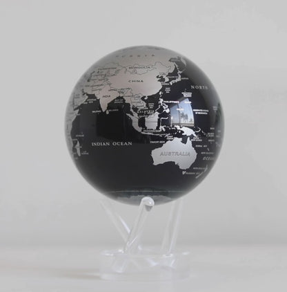 Jet black and silver MOVA globe rotating on acrylic base in modern product showcase video