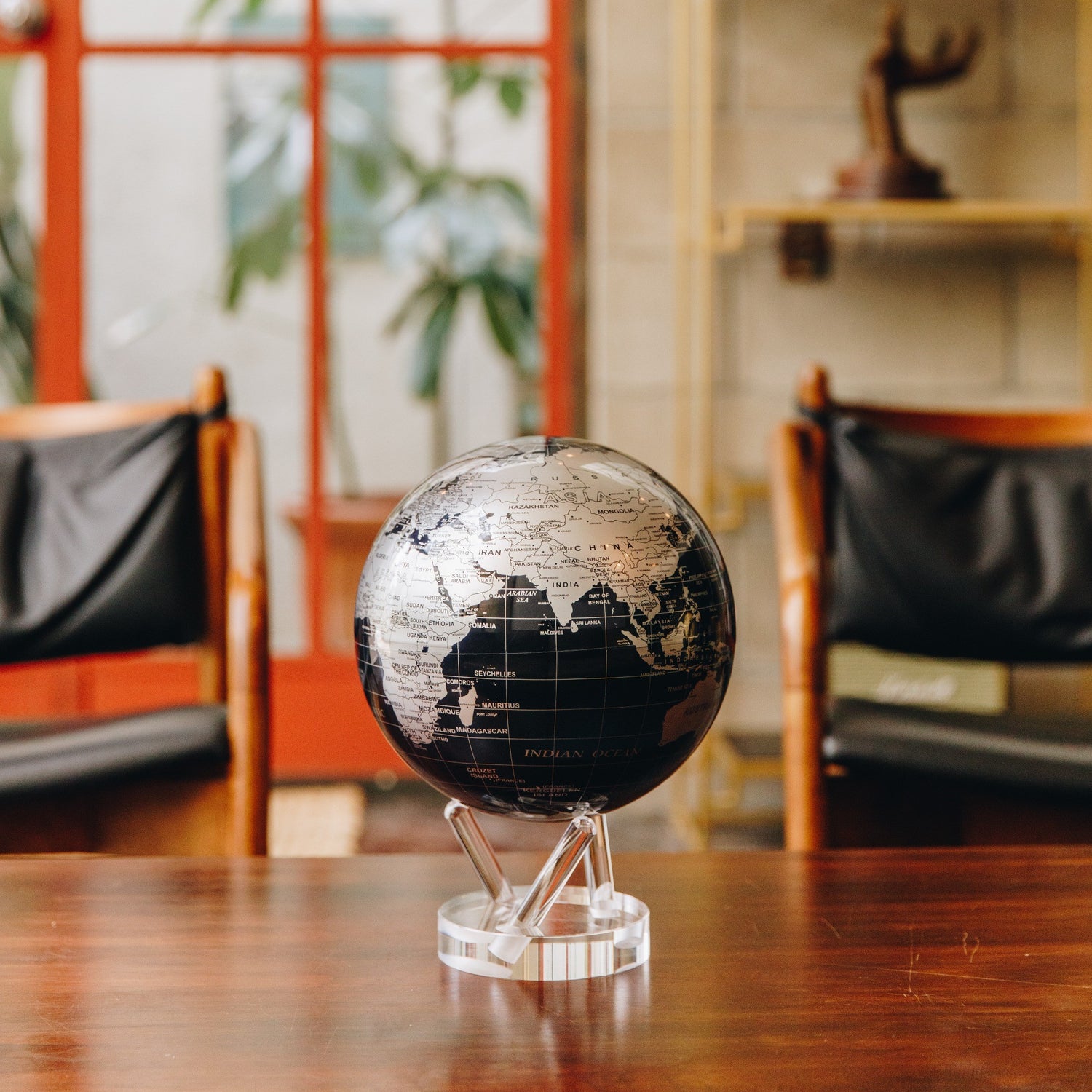 Jet Black &amp; Silver MOVA Globe displayed on wooden tabletop