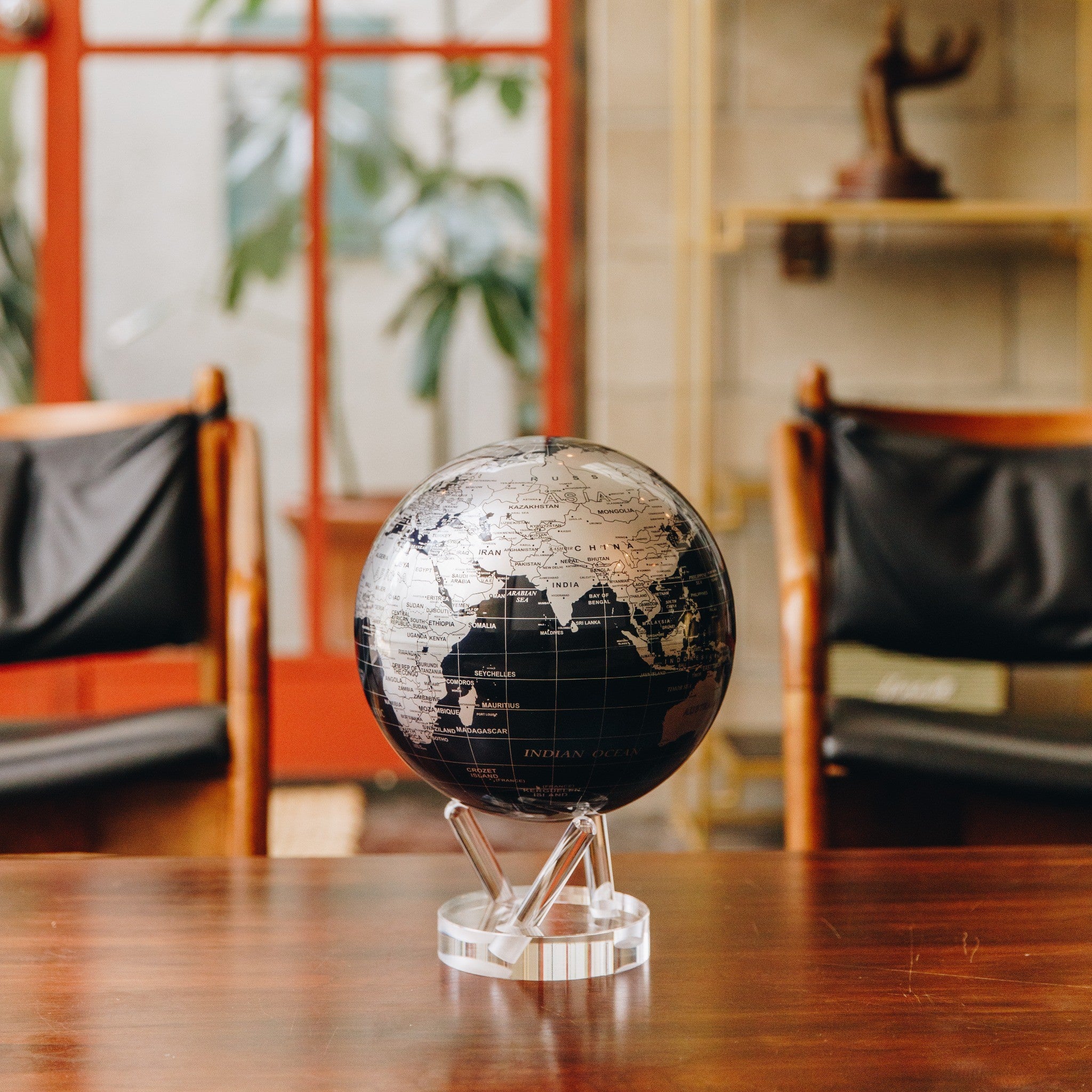 Jet Black &amp; Silver MOVA Globe displayed on wooden tabletop