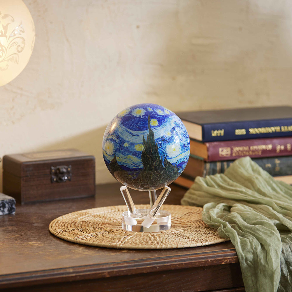 Van Gogh Starry Night MOVA Globe displayed on a wooden table with books and warm decor
