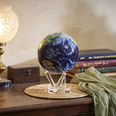 Earth with Clouds MOVA Globe displayed on wooden table beside books