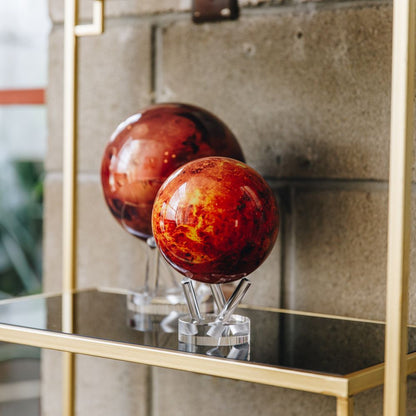 Venus MOVA Globe reflected on a glass shelf in a contemporary home interior