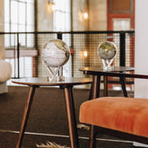 Antique Cassini White MOVA Globe displayed on café tables in a modern interior setting