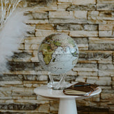 Antique Cassini White MOVA Globe on a side table against a stone accent wall